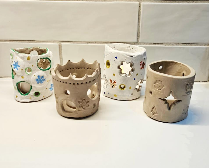 art project for kids shows four completed clay pots.