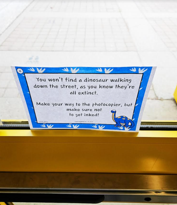free dinosaur scavenger hunt shows a printed scavenger hunt clue taped in a door.