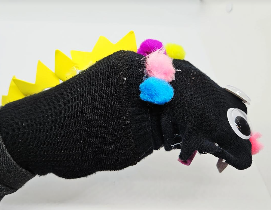 dinosaur craft for kids shows a dinosaur with spikes sock puppet.