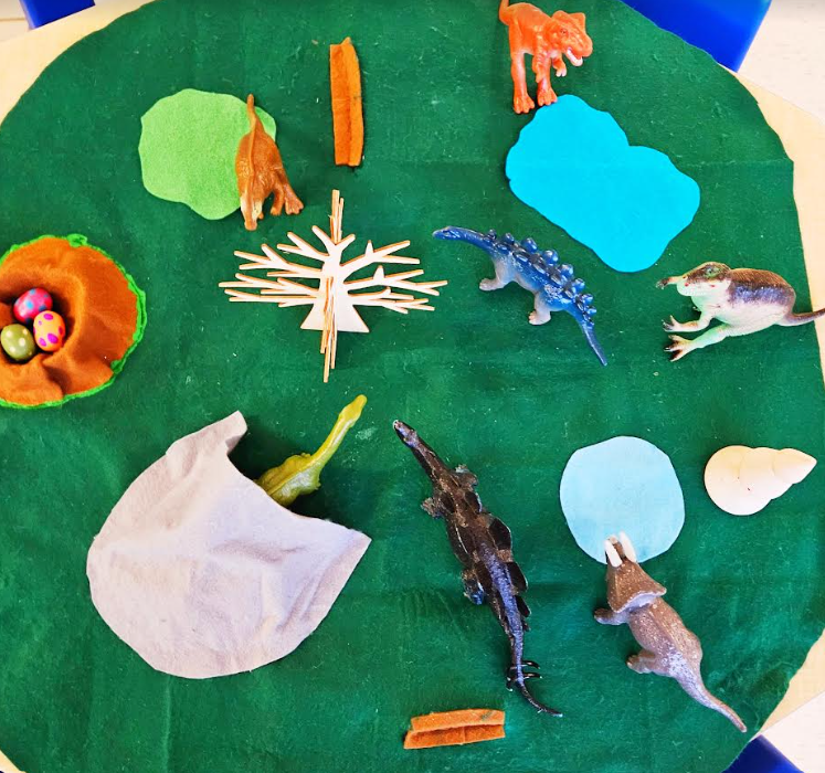 dinosaur activities for kids shows a felt play mat with dinosaurs on it.