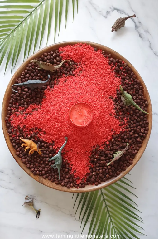 dinosaur activities for kids shows a DIY volcano in a sensory container.