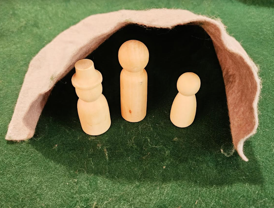 small world play shows three wooden figures inside a felt cave.