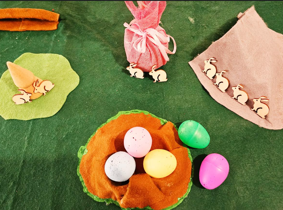 small world play shows an easter or spring themed play mat with eggs, bunnies.