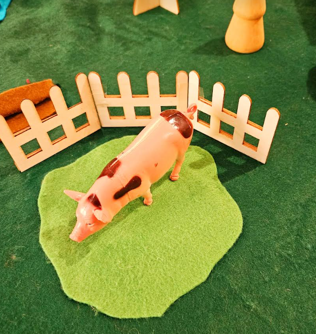 preschool center shows a pig figure on a piece of green felt.