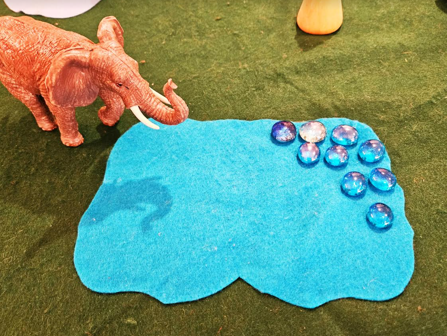 kindergarten centers shows a plastic elephant by a felt water.