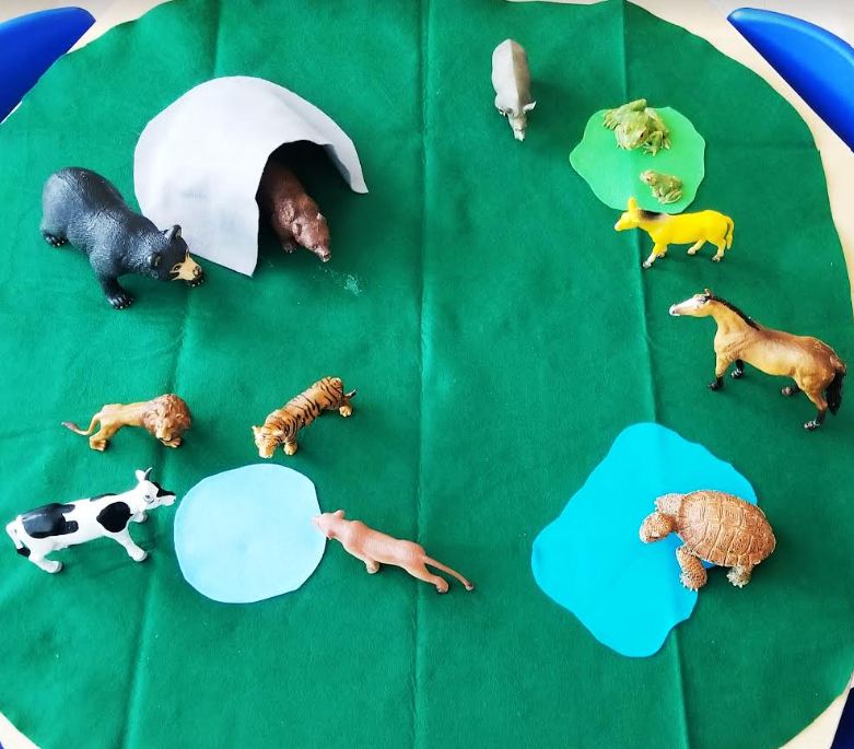 farm play for kids shows plastic animals on a large felt play mat.
