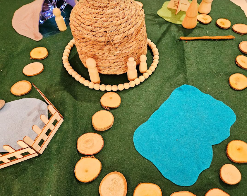 small world play shows a felt mat with wood slices and natural props on it.