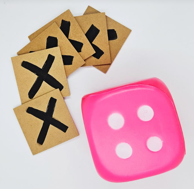 math coding game shows a stack of wooden squares with an X on each and a pink die.
