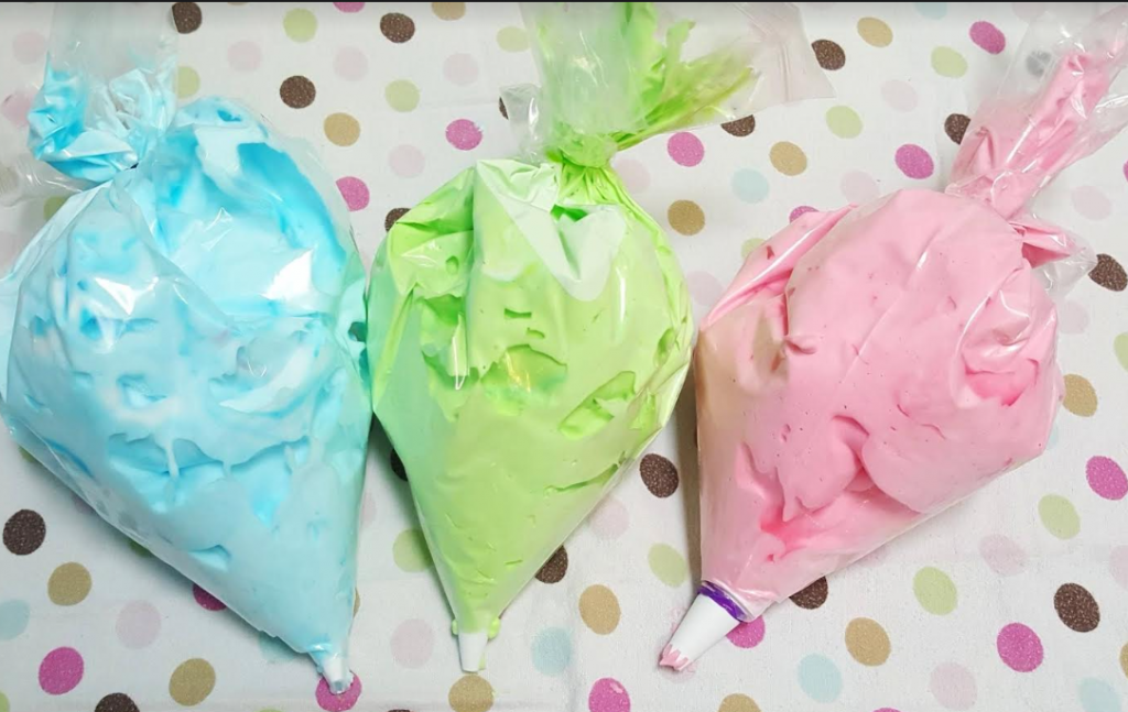 sensory activity for kids shows three icing bags filled with blue, green and pink shaving cream.