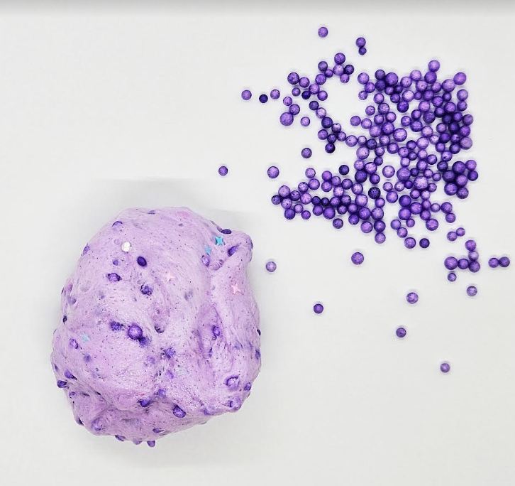 slime project for kids shows a ball of purple slime and little purple balls.