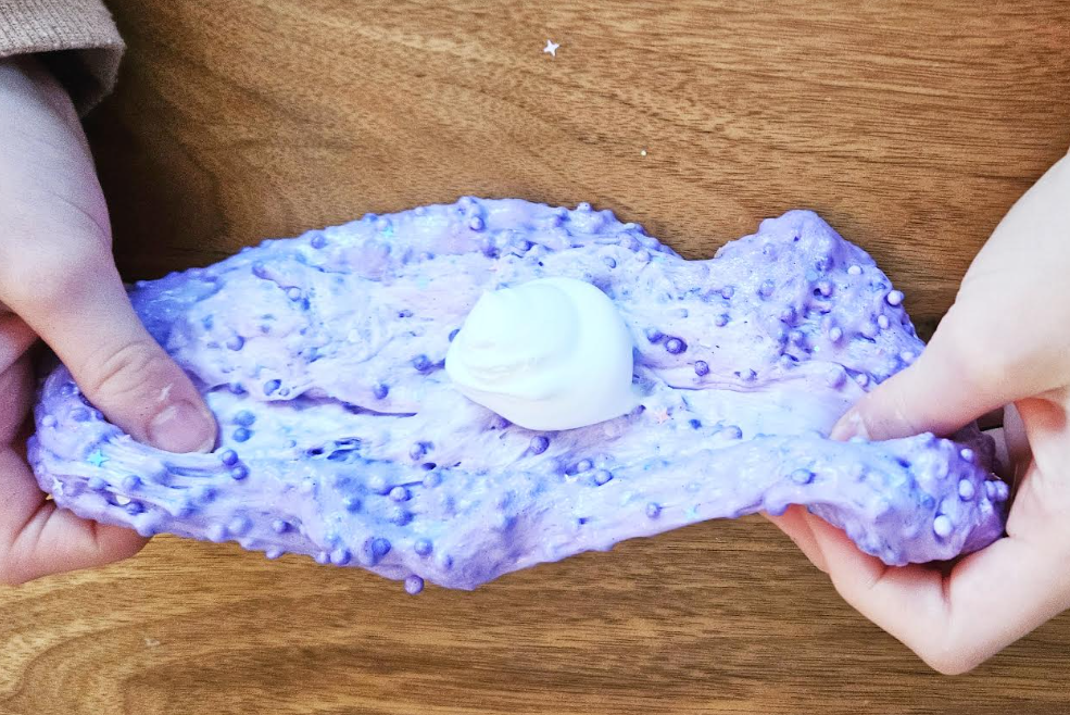 slime project for kids shows a child mixing purple slime.