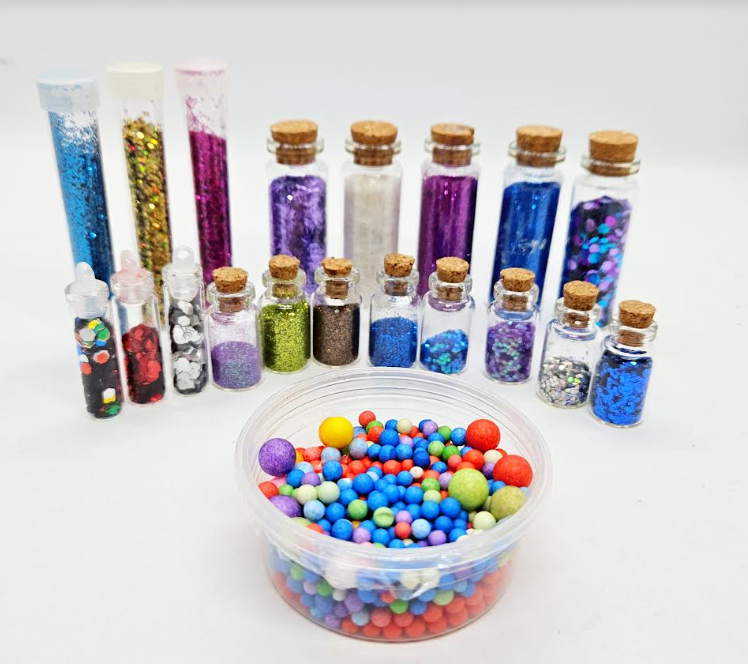 slime creation for kids shows an array of small glitter jars and foam balls.