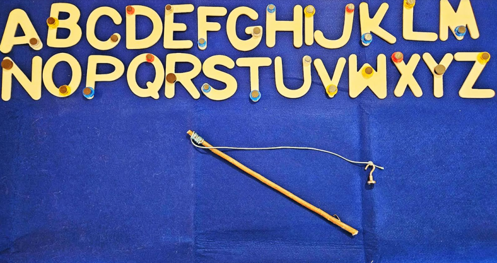 alphabet activity for kindergarten shows the letters of the alphabet each with a small magnet and a DIY fishing rod.