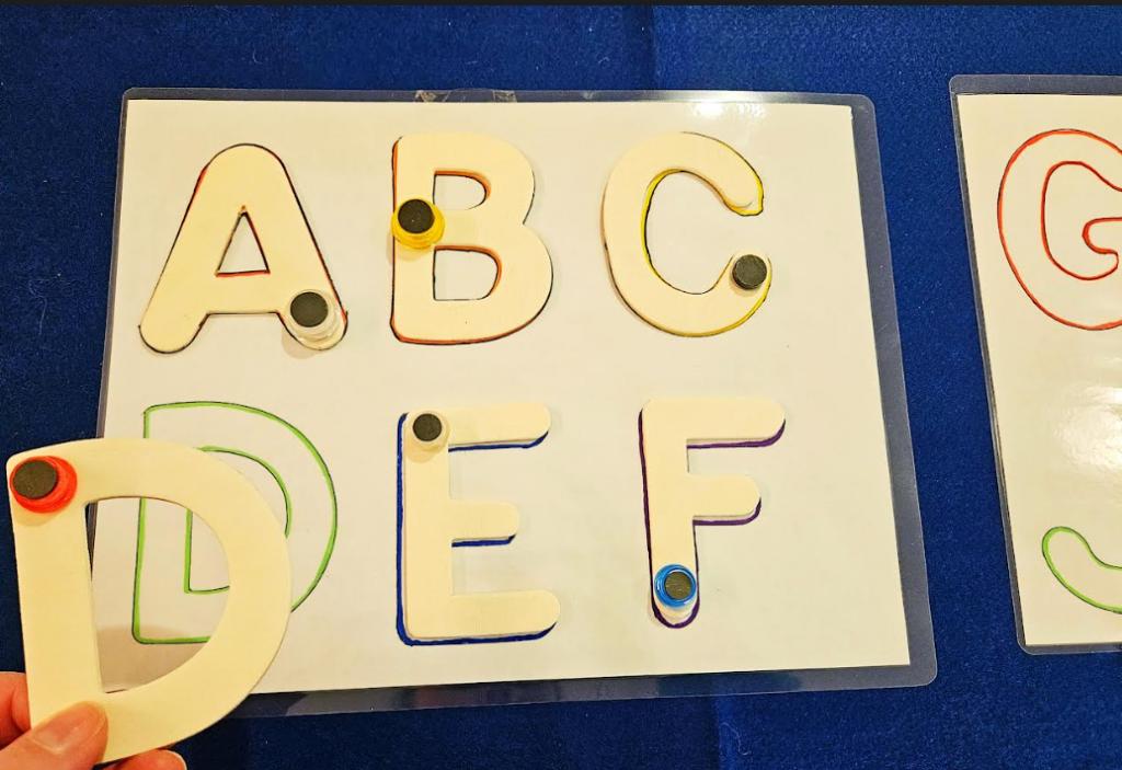 letter games shows a alphabet page with wooden letters of the alphabet with the letter D being set on the board.