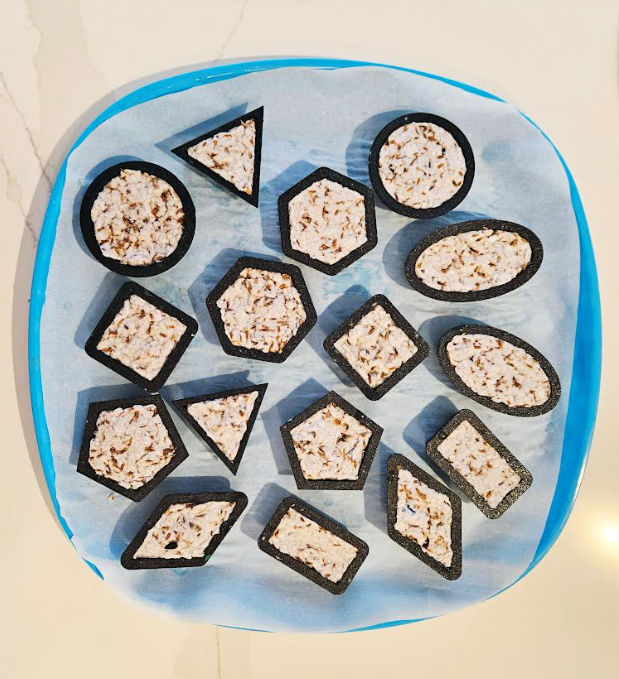 diy recycled seed bombs shows a tray with a bunch of 2d shape cookie cutters filled with seed bombs.