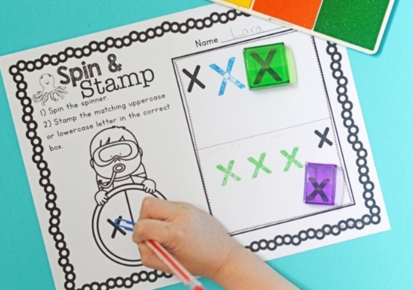letter recognition game shows a spin and stamp printable page for the letter X.