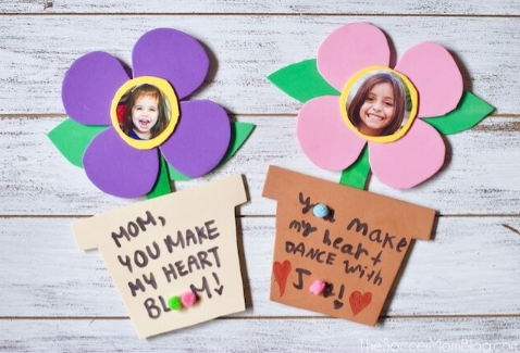 Mother's Day Gifts for Kindergarteners to Make shows two hand made flowers with kids pictures on them.