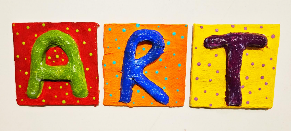 paper mache art for kindergarten shows the letters ART painted and made from paper mache.
