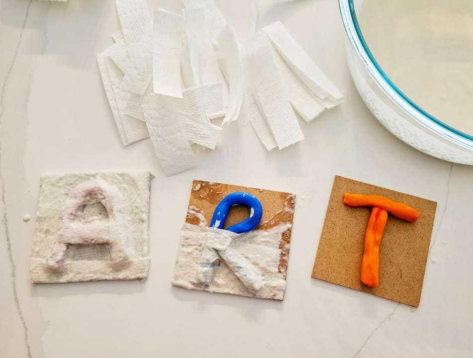 paper mache art for kindergarten shows the letters ART partially covered in paper mache.
