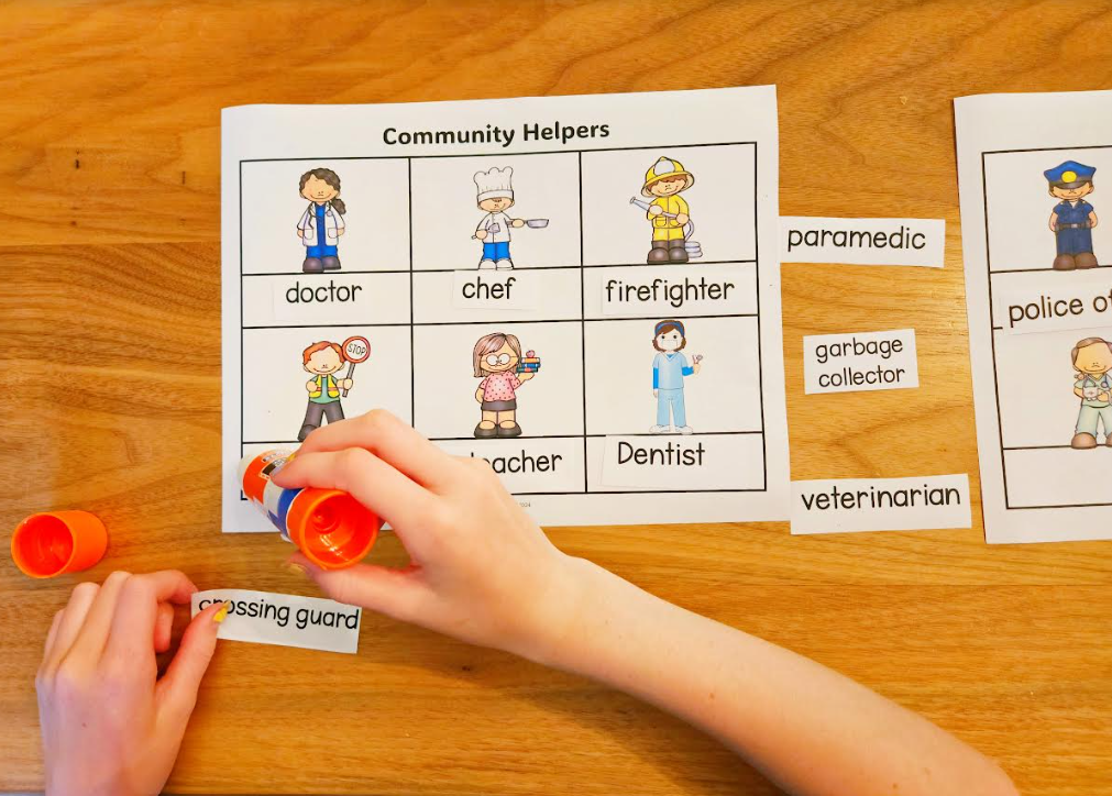 community helpers worksheet shows a child gluing a name on the worksheet. 