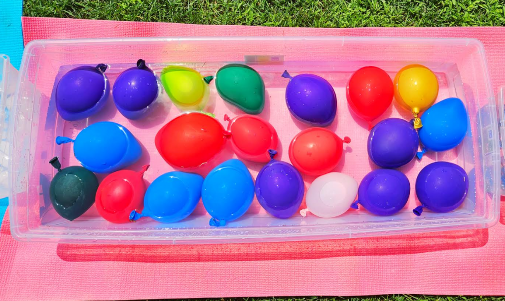 summer sensory path shows a long bin filled with water balloons.