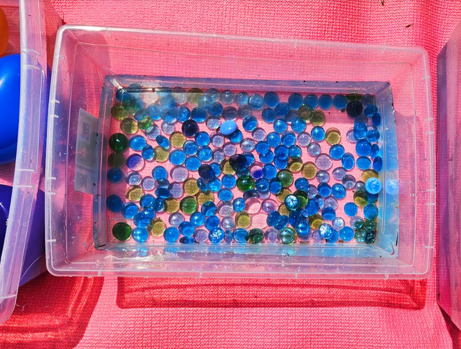 summer activity for kids shows a bin with blue beads in it.