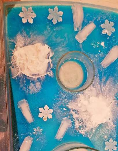 DIY winter sensory tray shows shaving cream added to a layer within a sensory bin.