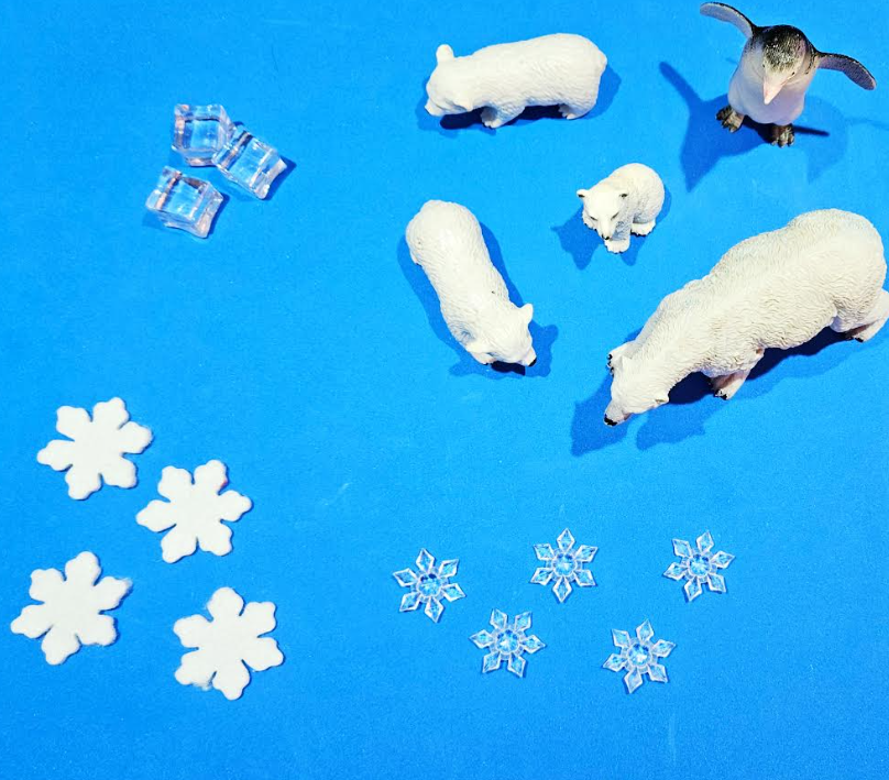 arctic adventure activity shows plastic animal figures, snowflake gems and fake ice cubes to use in play trays.
