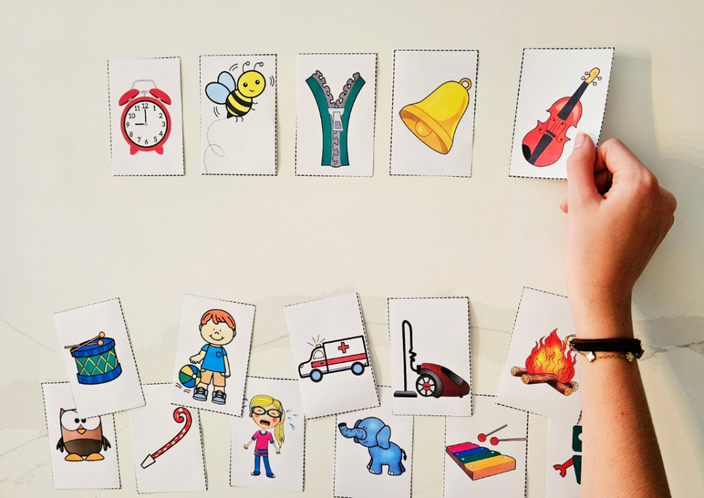 free preschool music activity shows a child placing a violin card beside a collection of other cards with images.