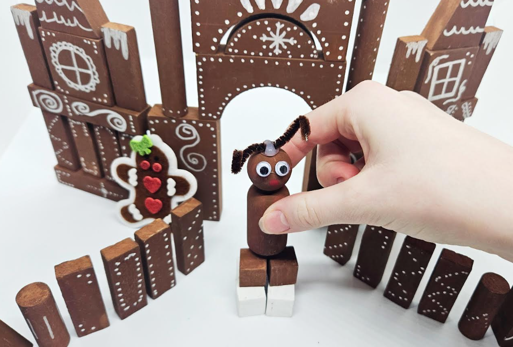 Holiday building activity shows wooden blocks that look like gingerbread pieces and a reindeer made from a wooden peg.