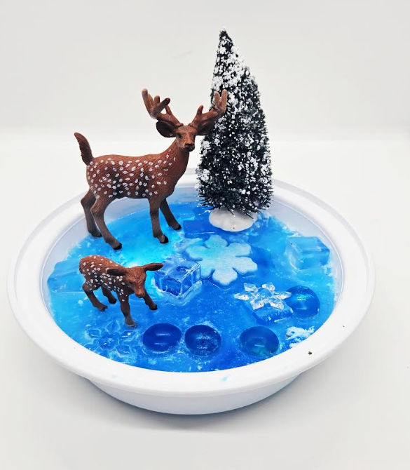 DIY winter sensory tray shows two deer in a small tray of frozen water.