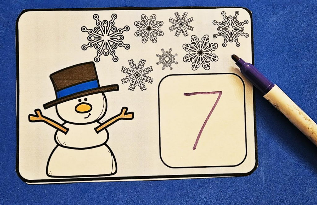 free winter math activity shows a printed page with seven snowflakes at the top and the number 7 printed in the box.